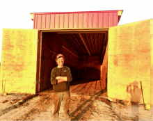 Conan Eaton in front of the world’s first documented aerated in-vessel compost heat recovery system at Auburn Star Farm in Lunenburg, Vermont.